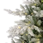 Detail zasnežených vetvičiek stromčeka Grandis s LED